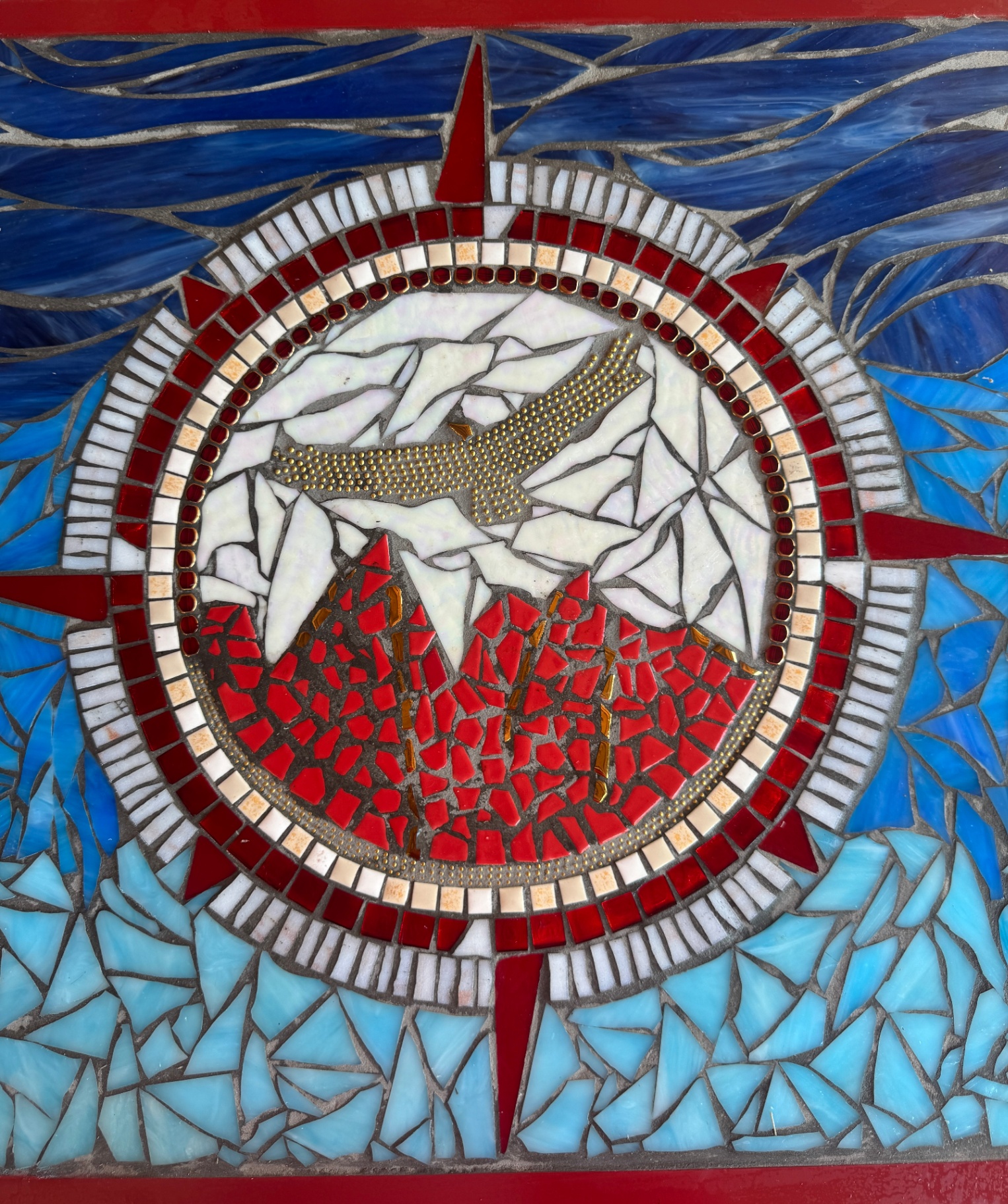 Stained-glass mosaic of mountains and a soaring bird