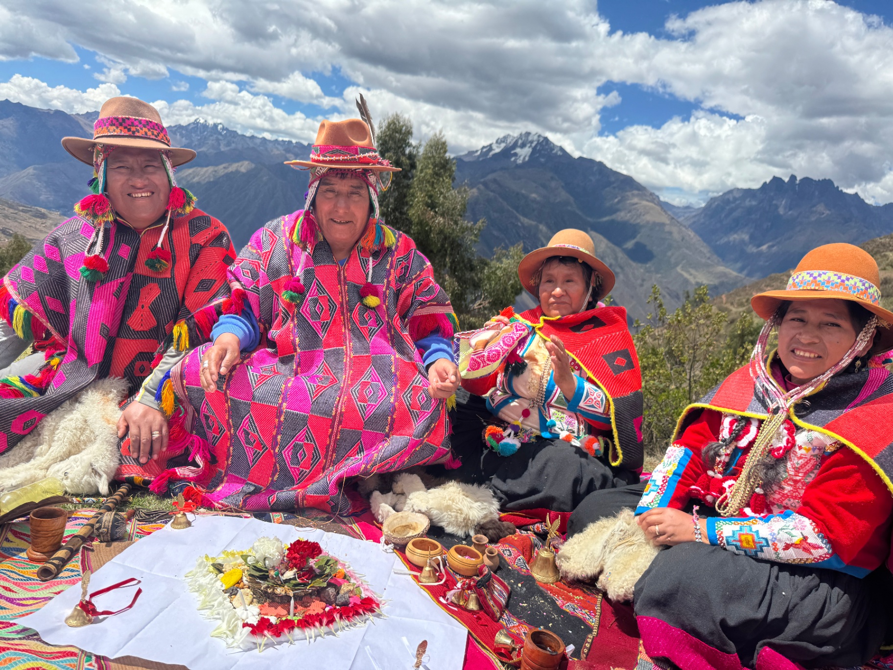 Q'ero shamans in traditional dress with a despacho offering in the Andes - Shamanic Trekker