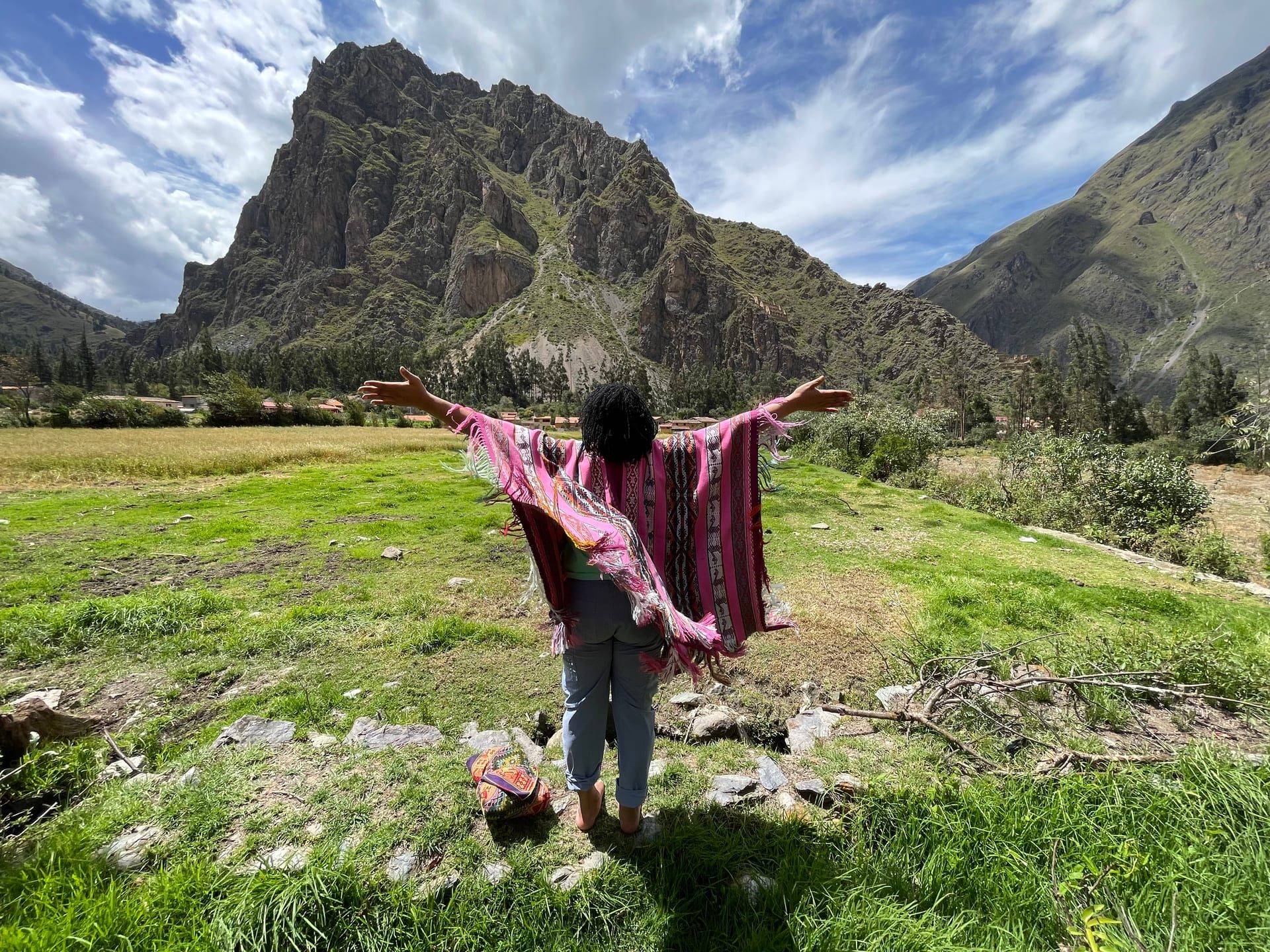 A figure in an Andean poncho stands with arms open before a sacred mountain — Shamanic Trekker Crestone Colorado annual visit